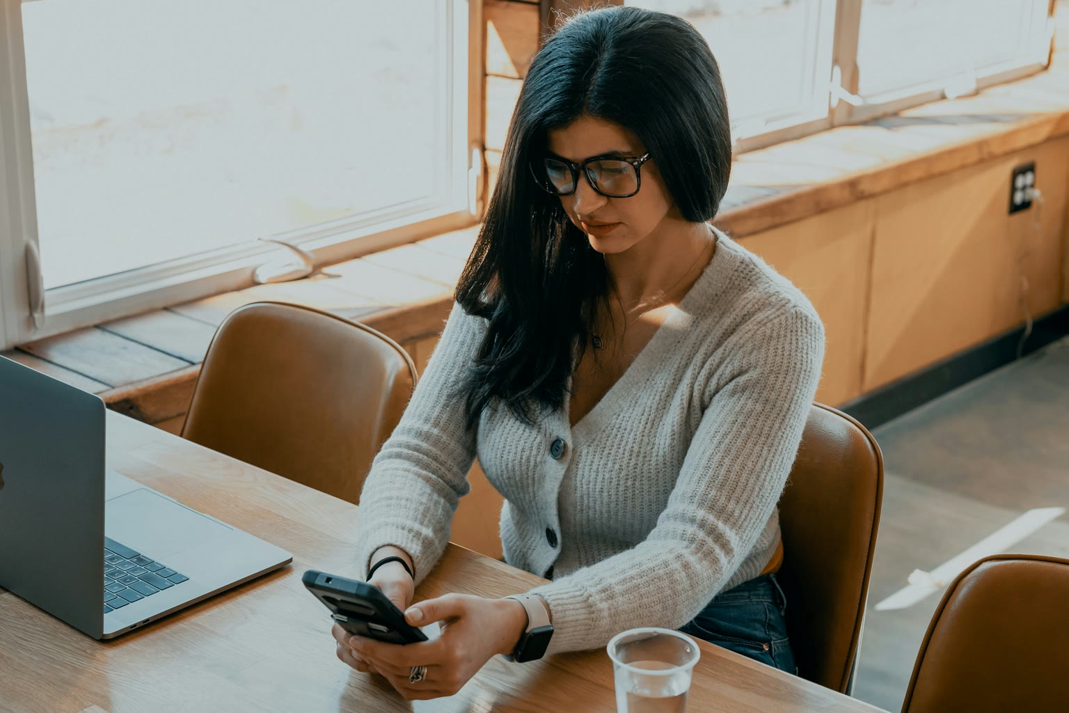 A customer looking down at a phone in warm afternoon light, like a real post-delivery reply moment.